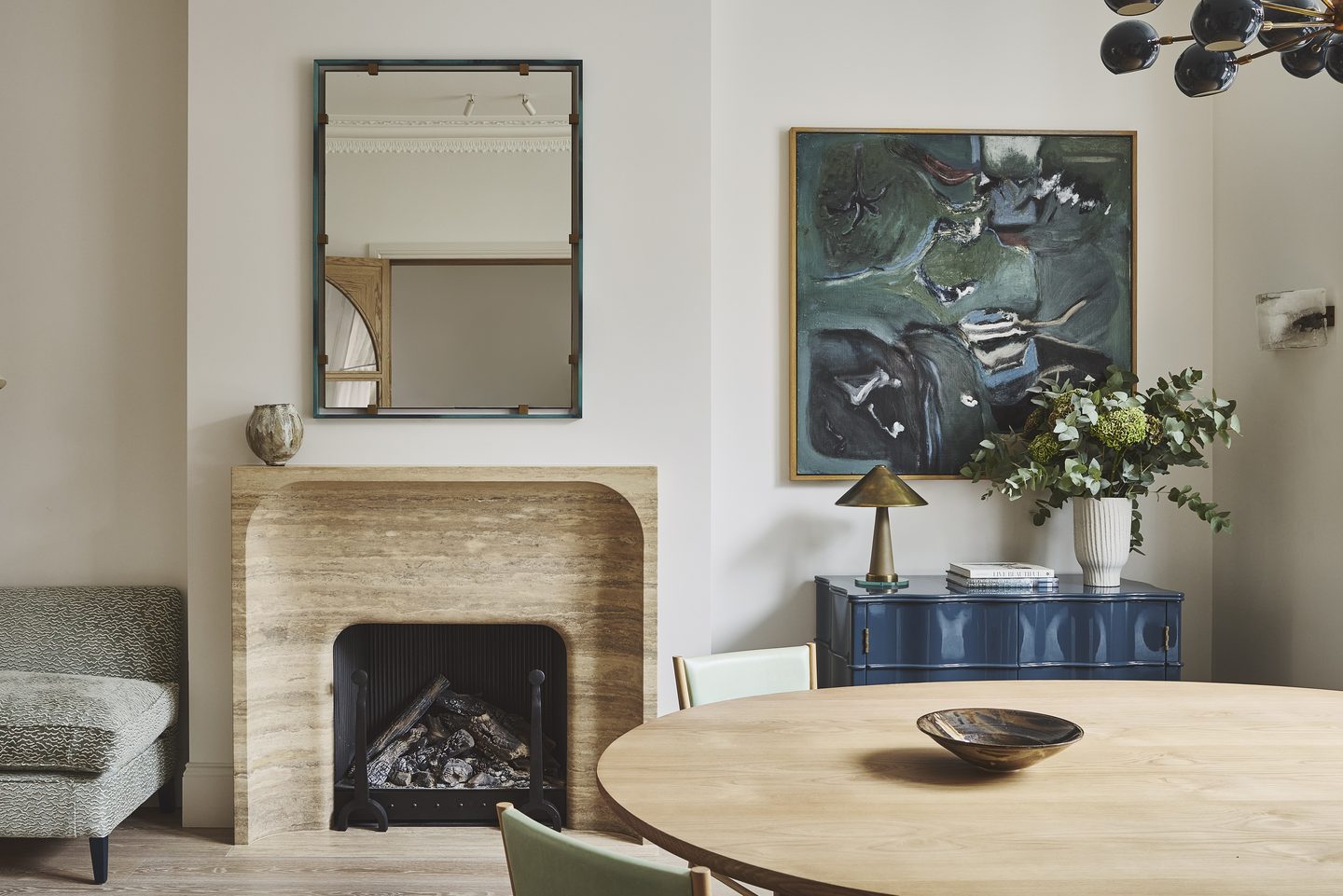 Dining room with travertine fireplace and lacquered blue sideboard