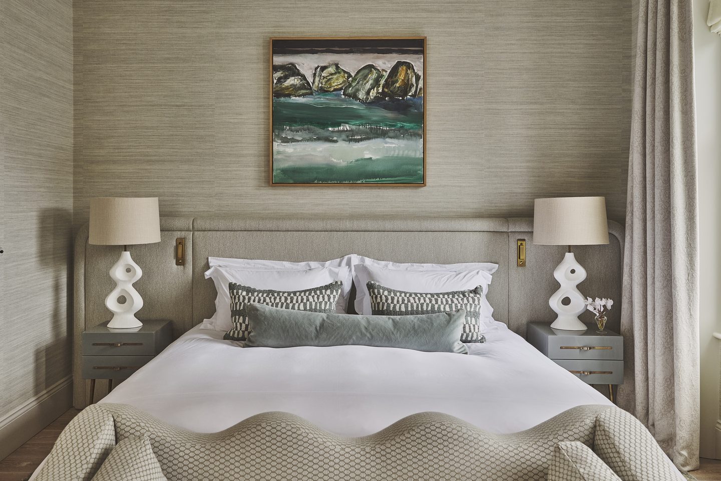 Principal bedroom with upholstered headboard and bedside lighting