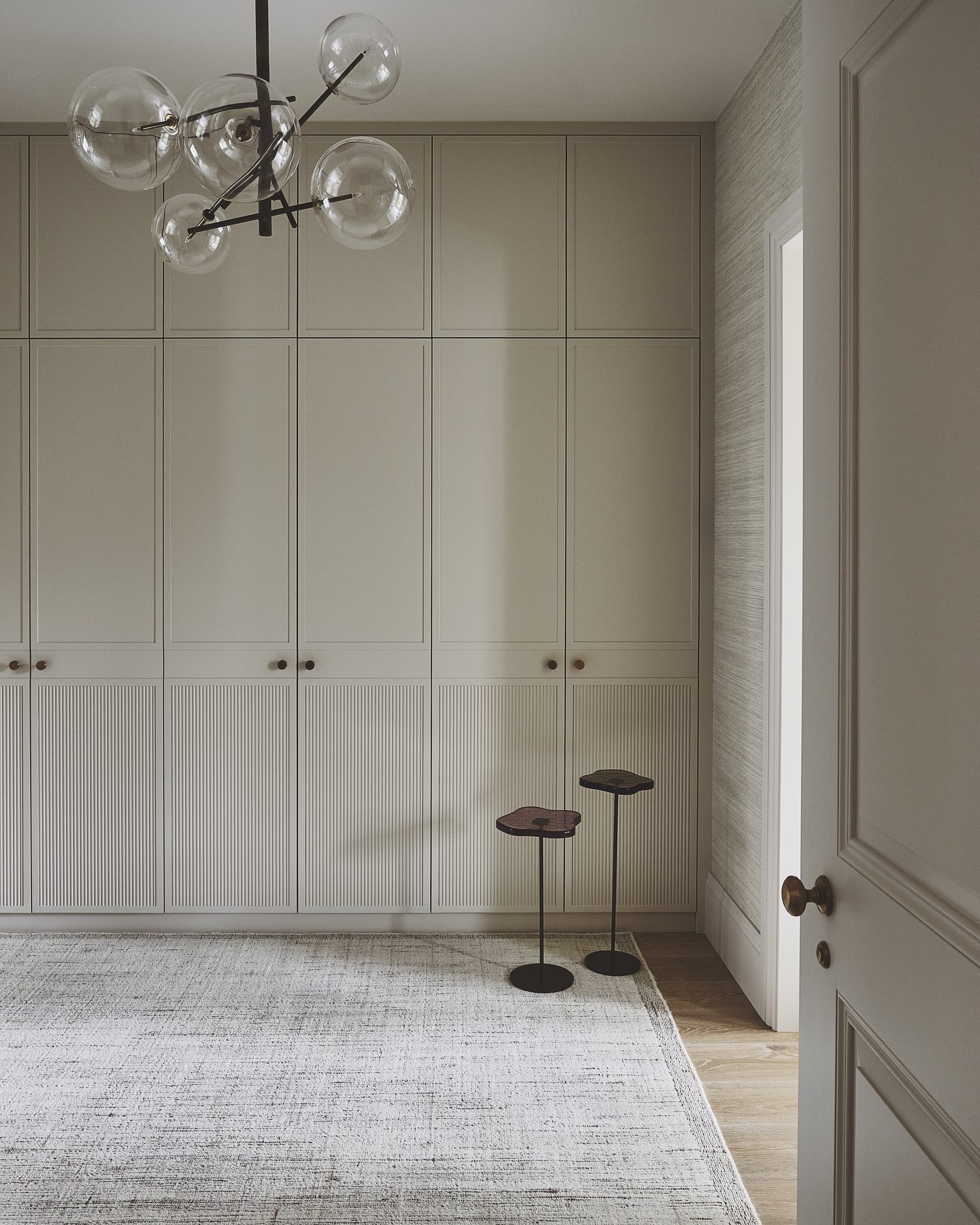 Dressing room with full-height fitted wardrobes and glass globe pendant