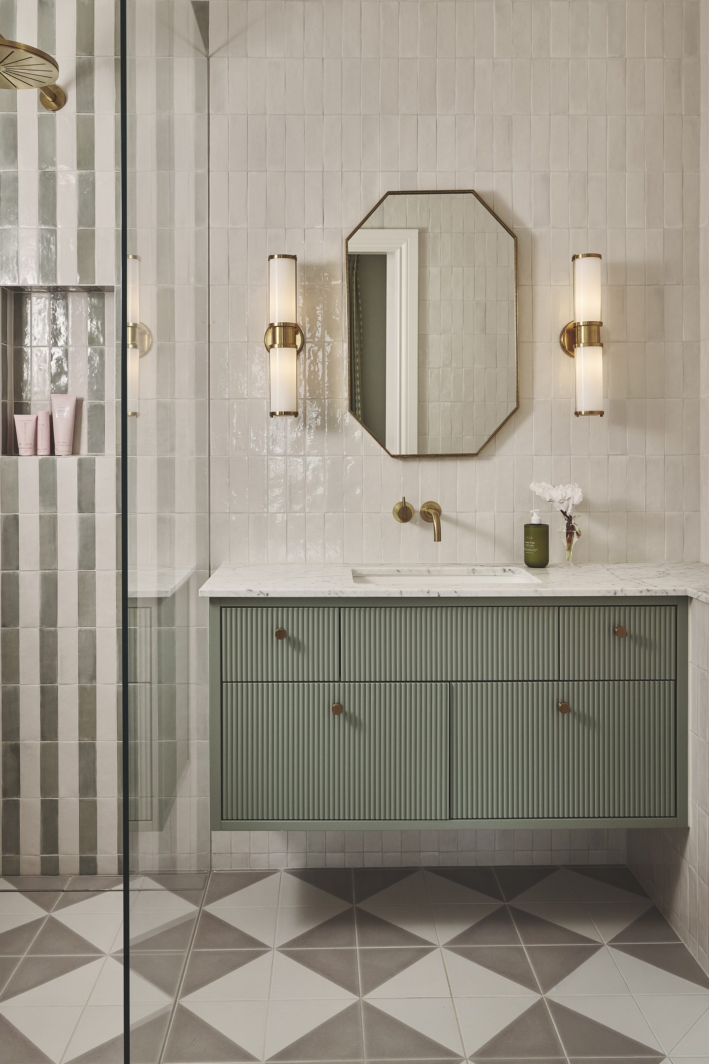 Bathroom with green fluted vanity, octagonal mirror and chequerboard marble floor