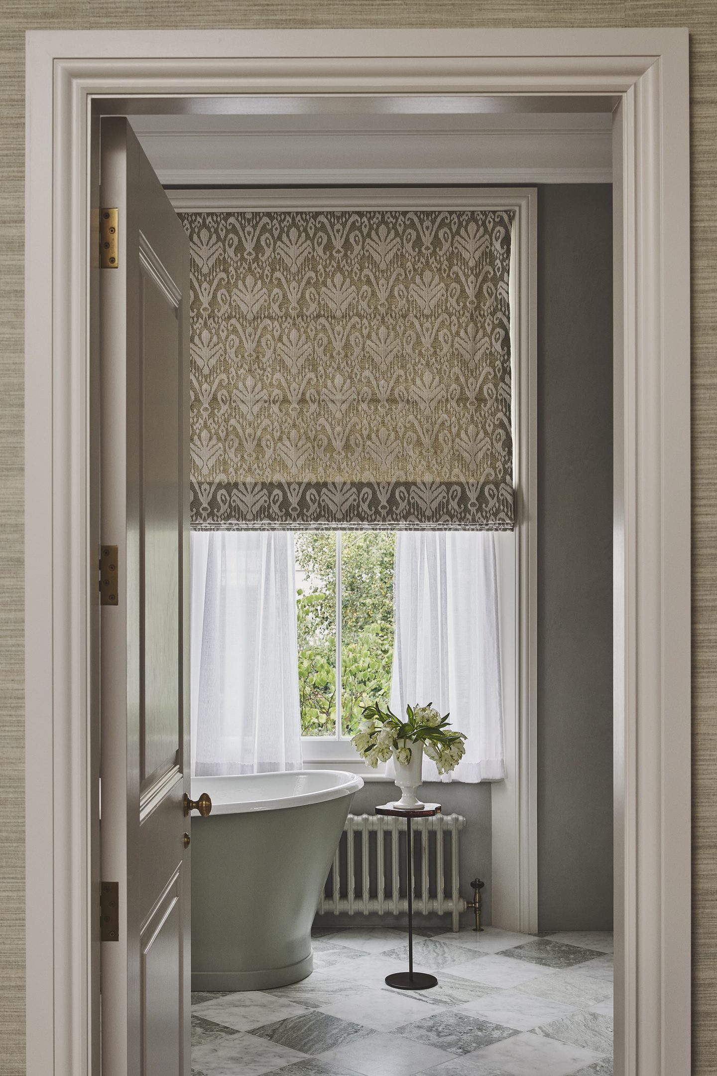 View through to the bathroom, with green freestanding bath beneath the window