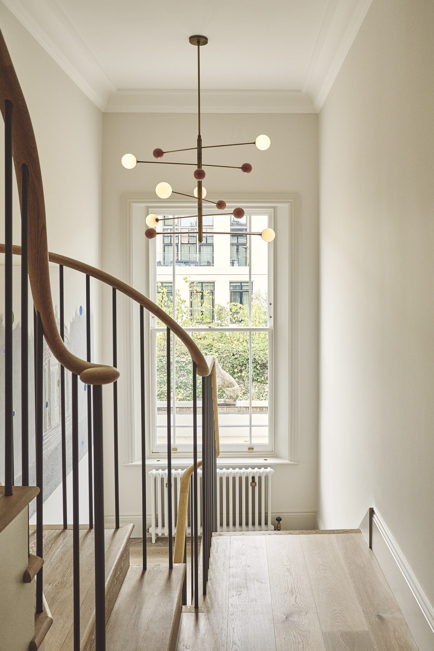 Staircase with curved timber handrail and slim black balusters