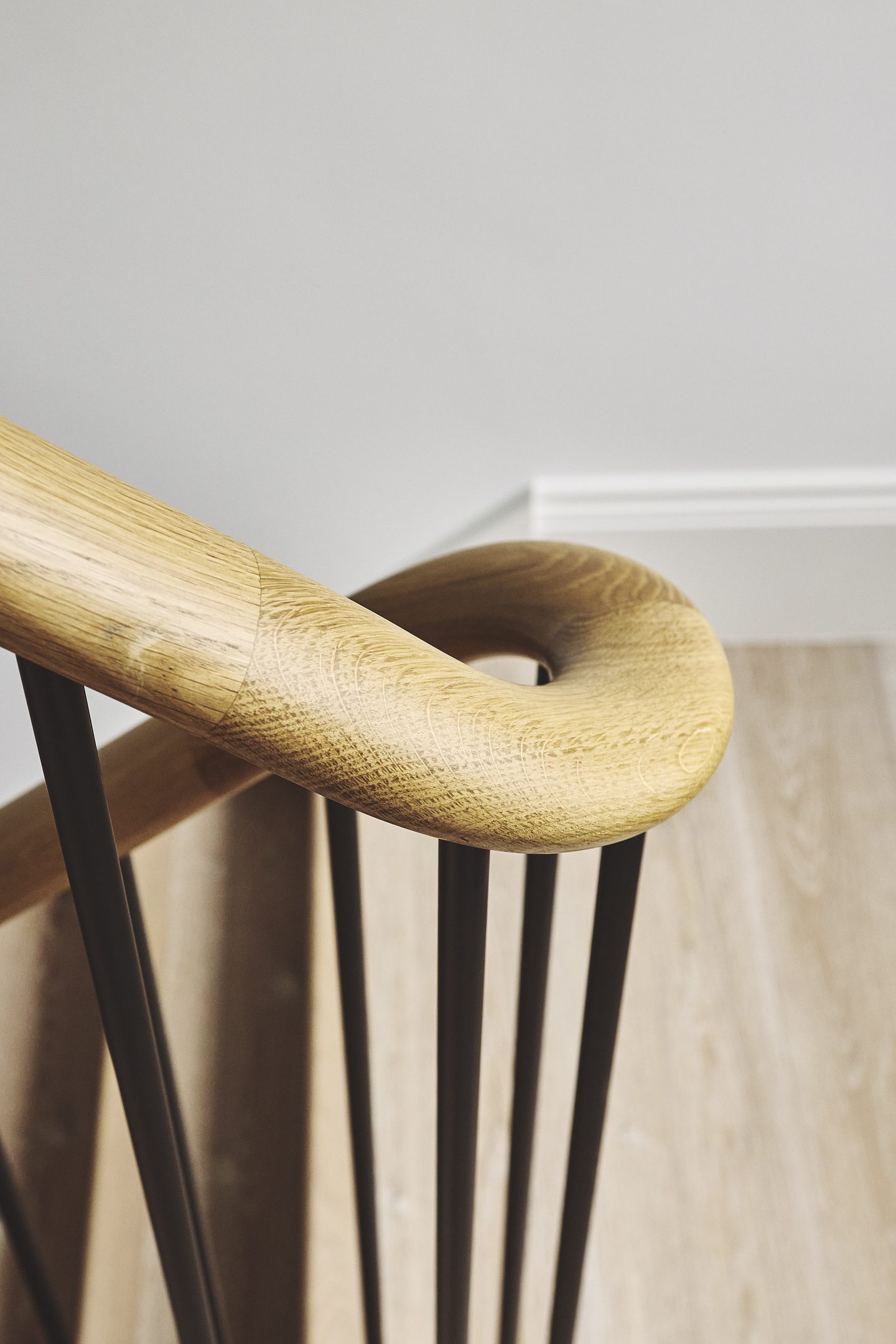 Detail of the curved oak handrail at the foot of the stair