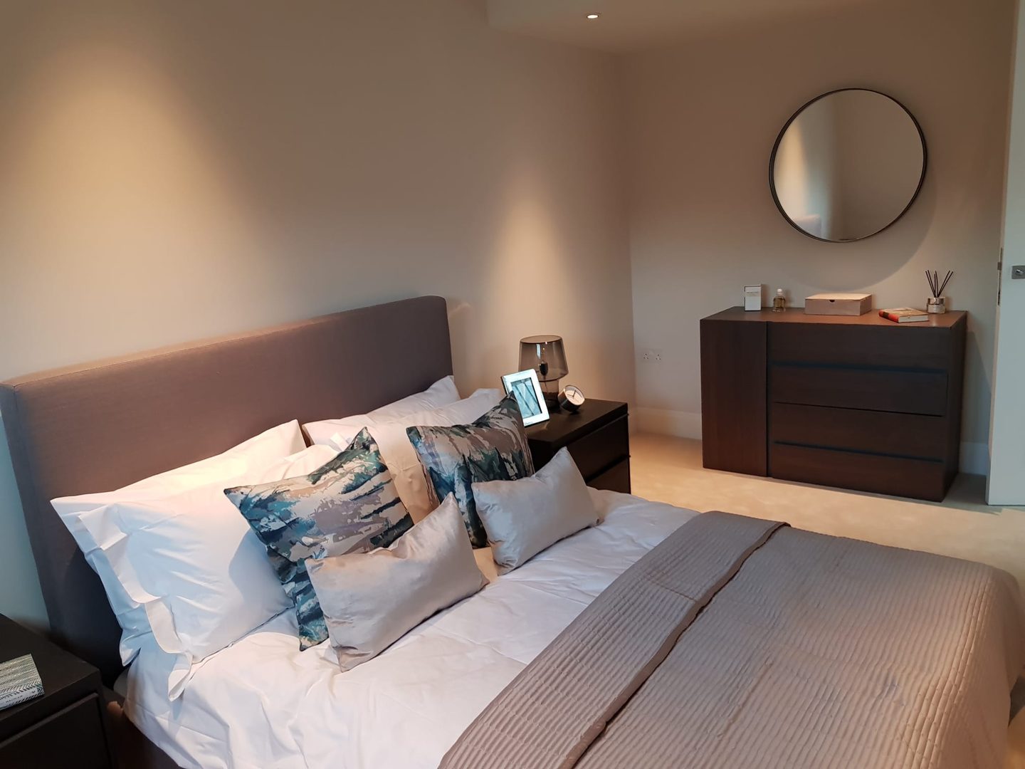 Bedroom with chest of drawers and round mirror