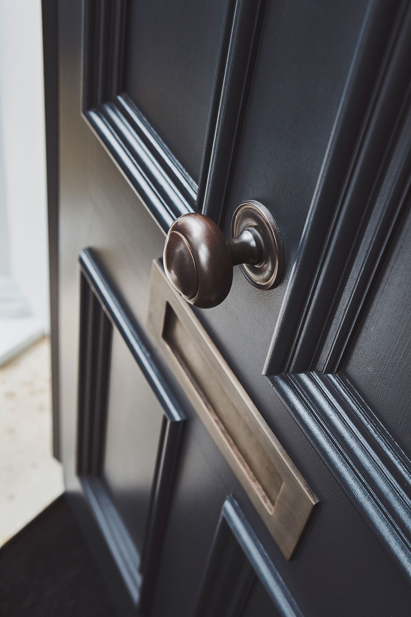The black panelled front door with brass ironmongery