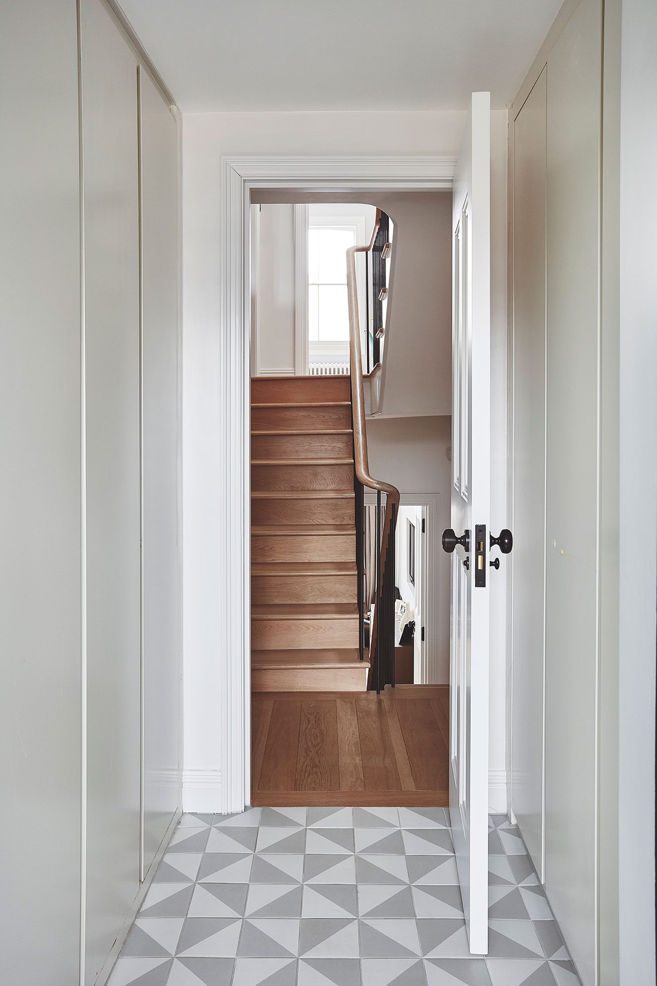 Hall with geometric tiled floor leading to the stair