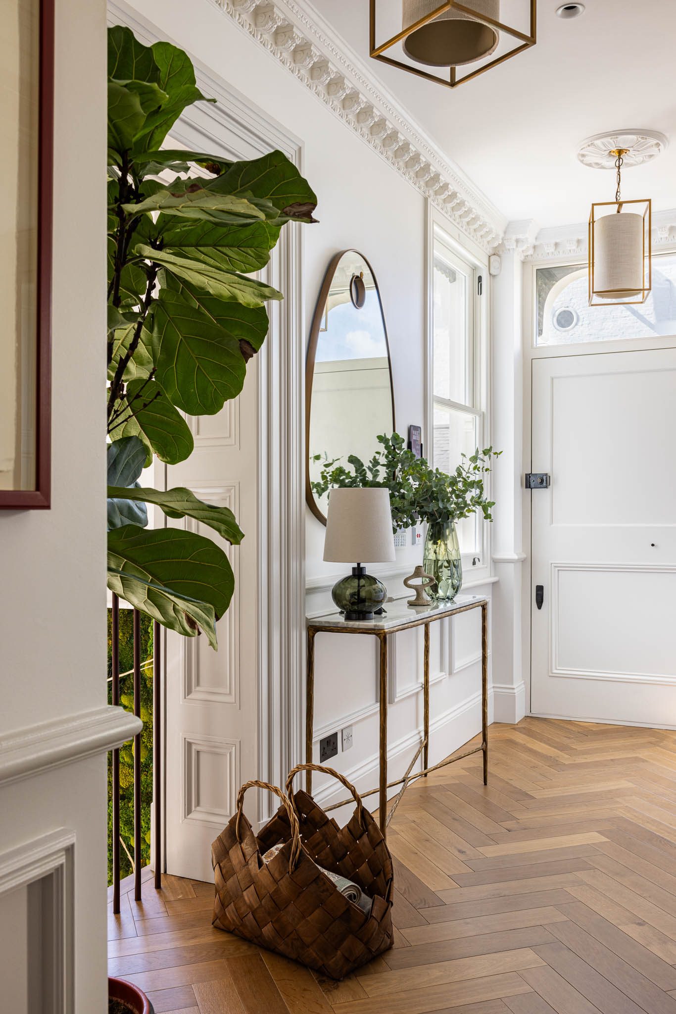 Entrance hall with herringbone floor and arched mirror