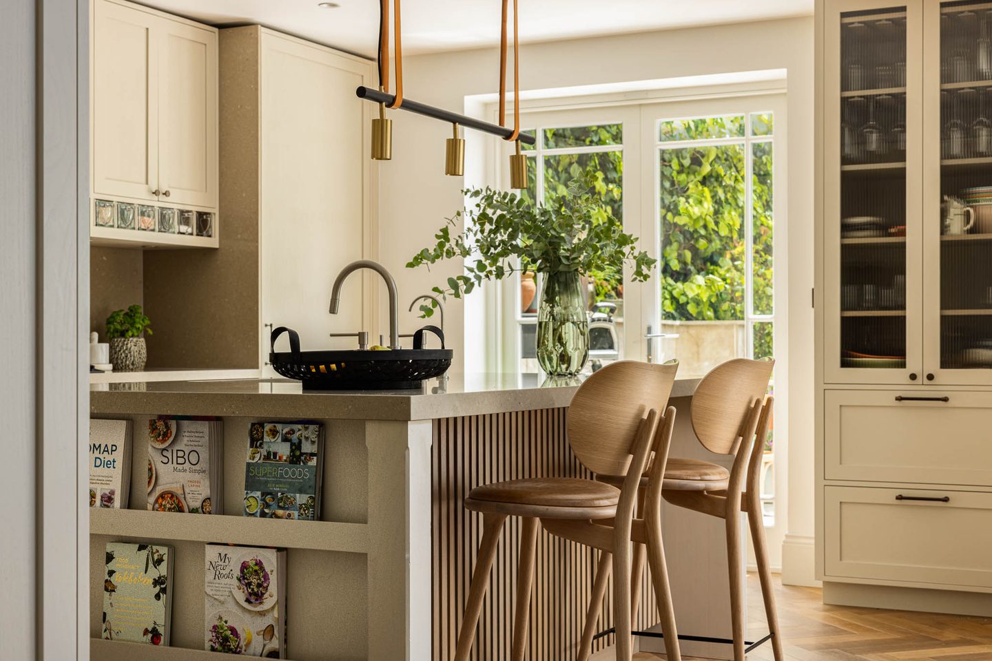 Kitchen breakfast bar with fluted island and doors to the garden