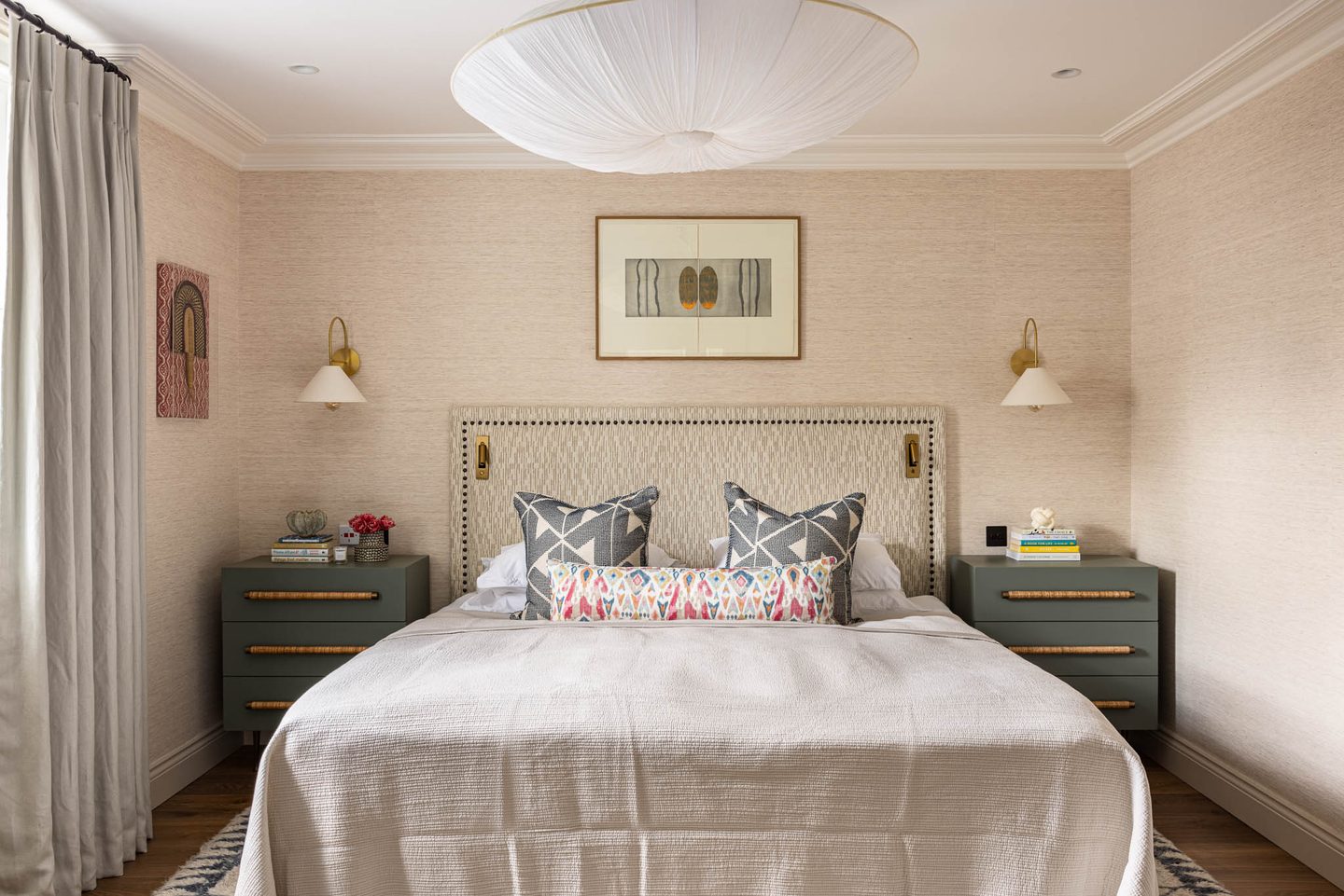 Bedroom with studded upholstered headboard and grasscloth walls