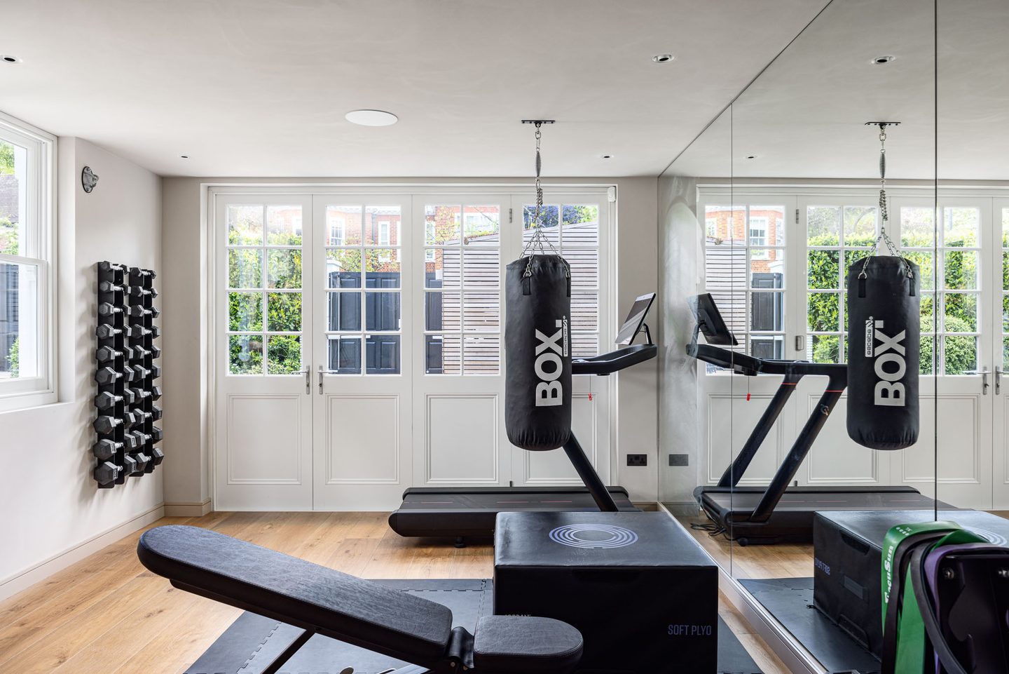 Home gym with mirrored wall and doors to the garden