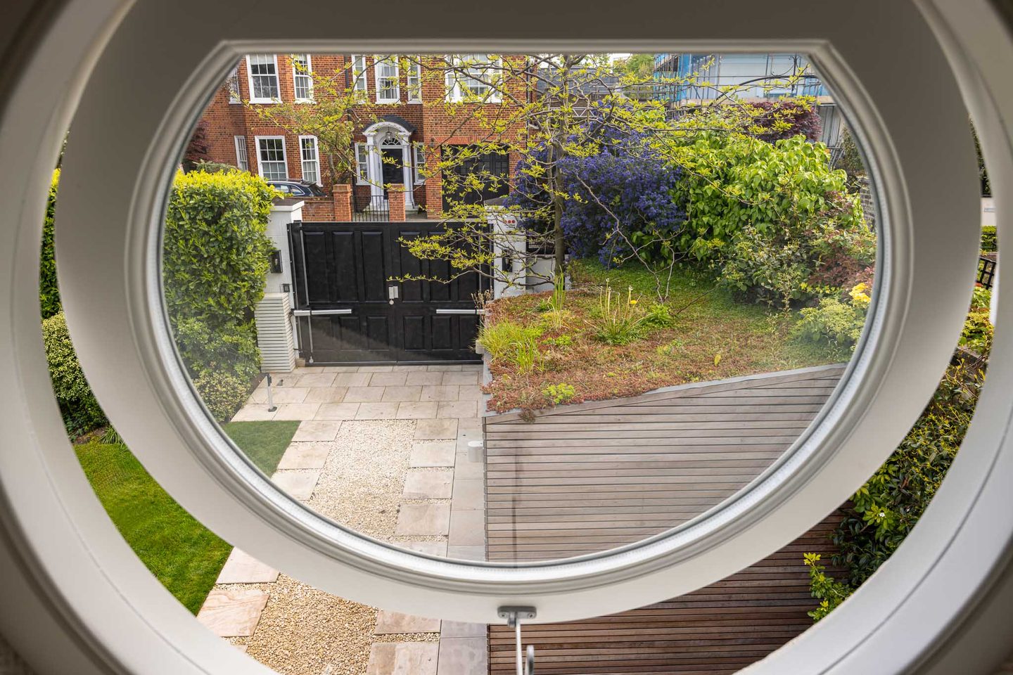 Circular window framing the garden and street beyond