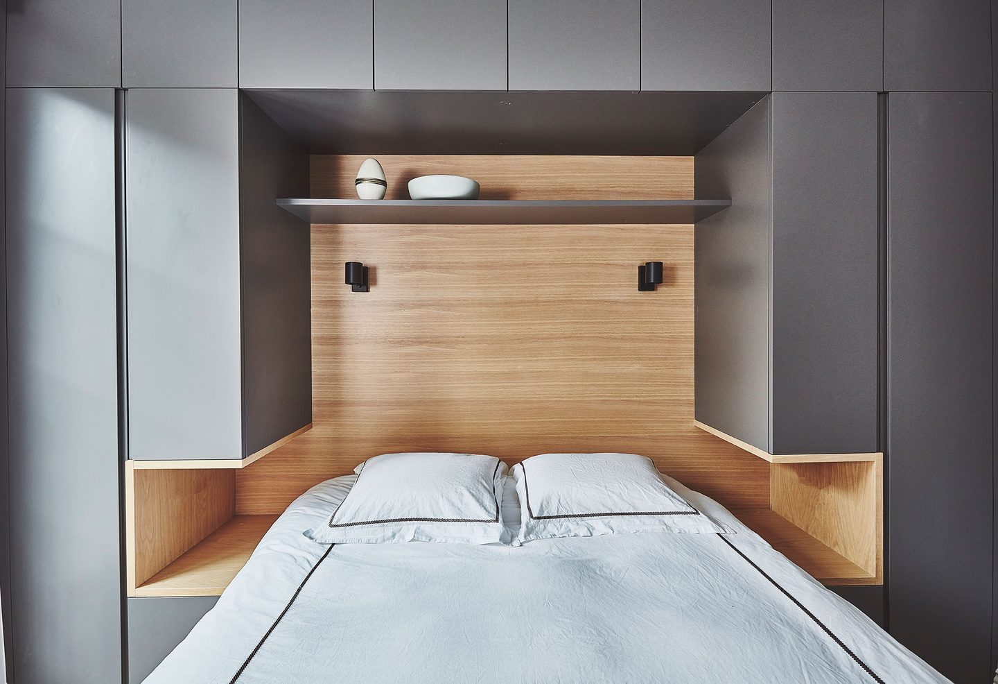 Bedroom with built-in oak bed and integrated shelving
