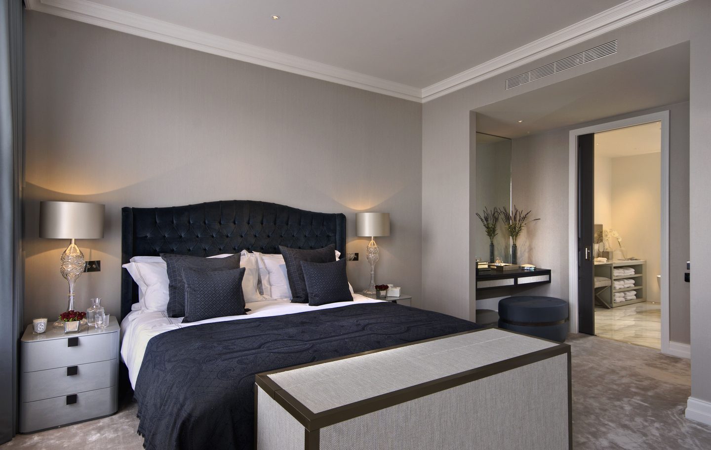 Bedroom with velvet headboard, looking through to the dressing room