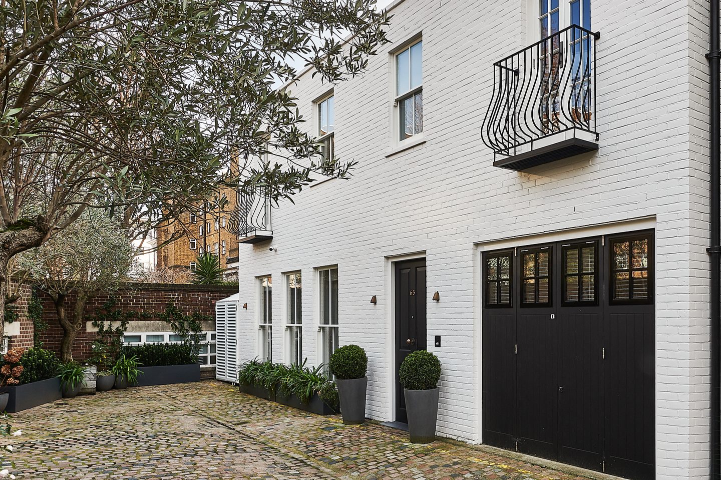The white painted mews house from the cobbled street