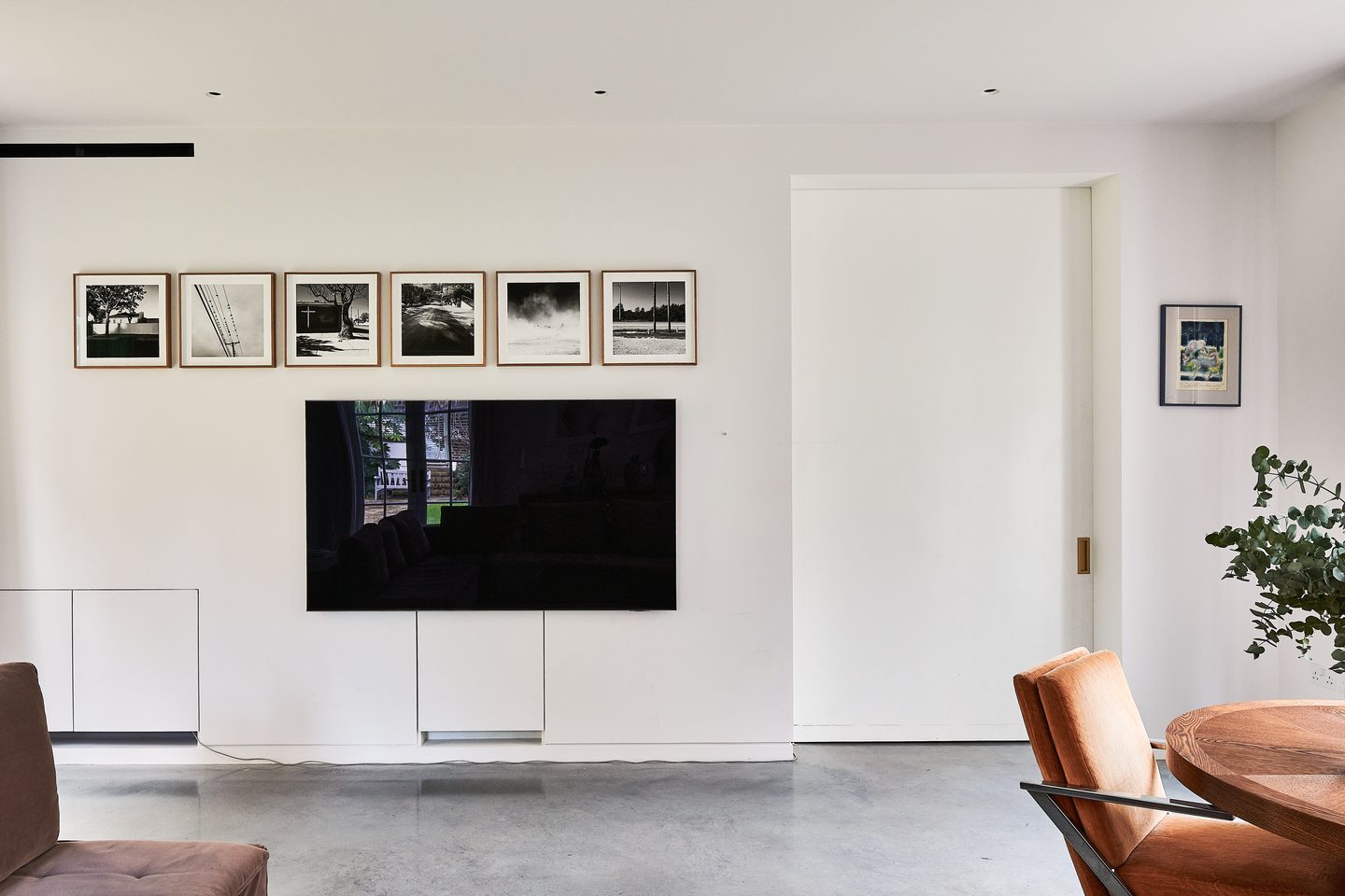 Living space with wall-mounted screen and framed prints