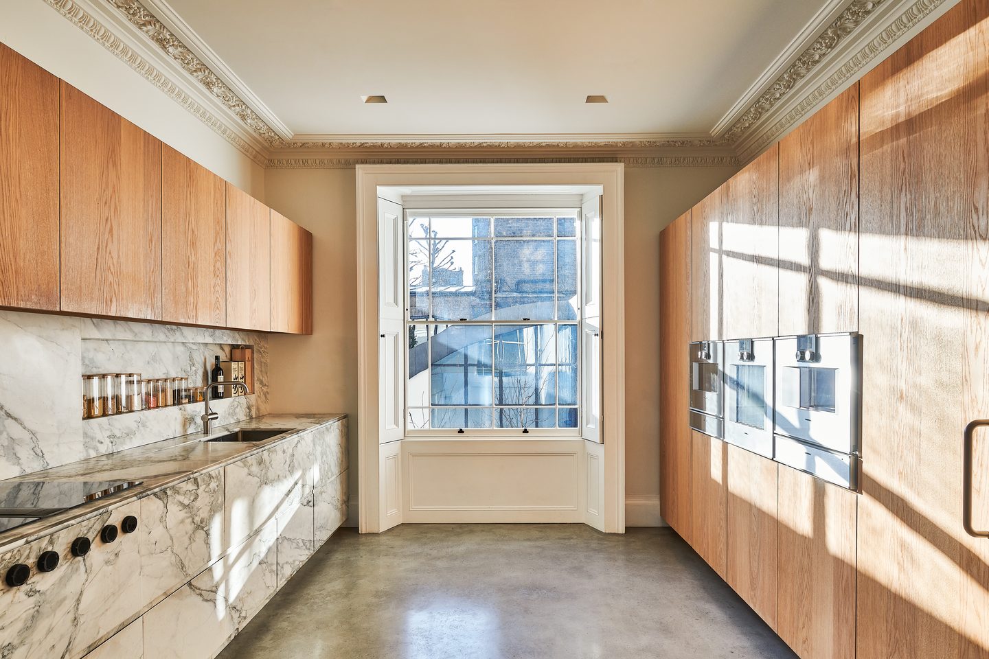 Kitchen with marble worktops, oak joinery and polished concrete floor
