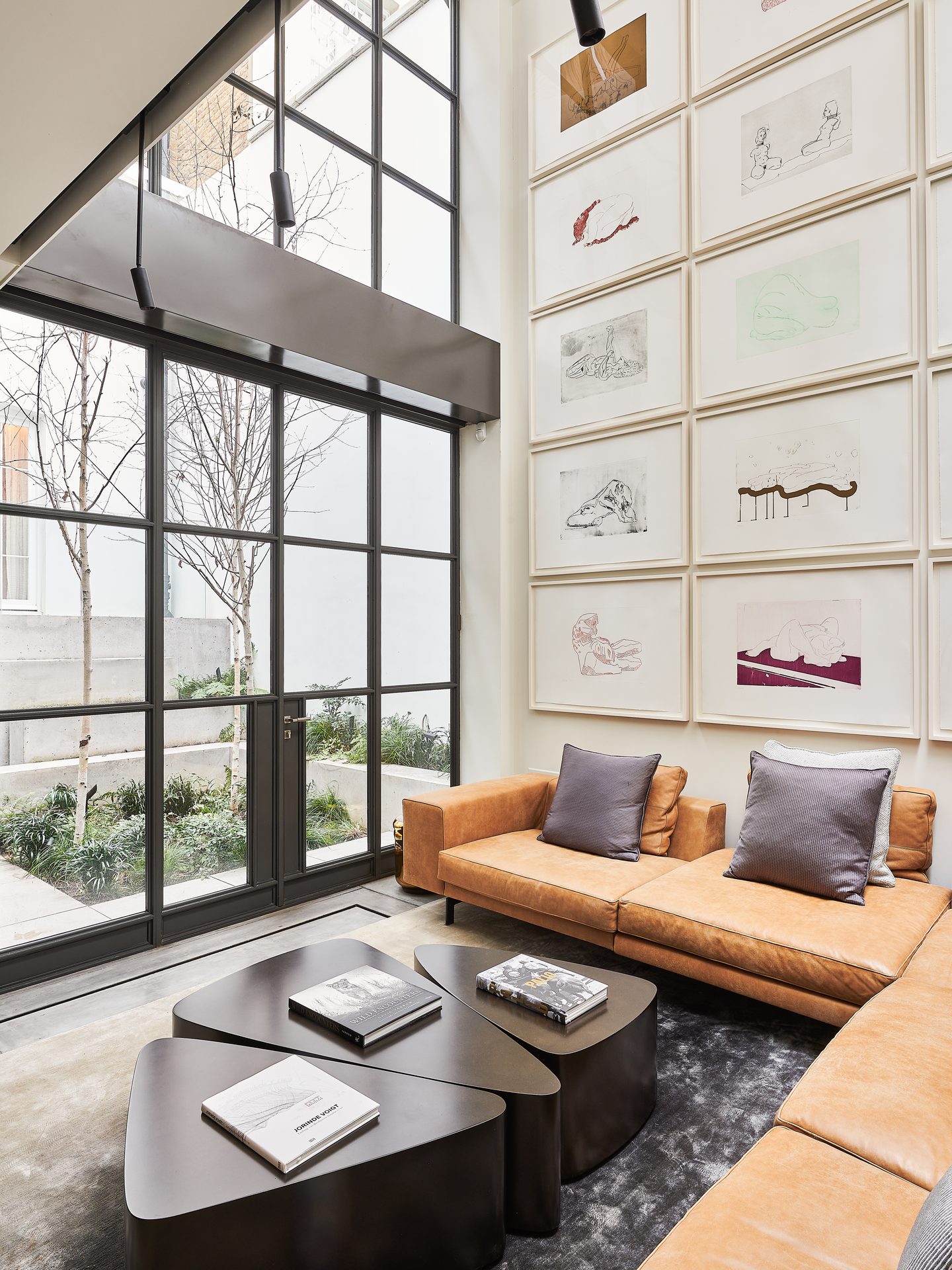 Double-height living space behind steel-framed glazing